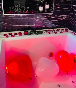 a pink bath tub with red balloons and roses at Relax Room proche PARIS Porte de Versailles in Malakoff