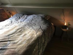ein großes Bett in einem Schlafzimmer mit einer Kerze auf dem Tisch in der Unterkunft Vakantiehuisje familytime - Chalet 122 in Durbuy