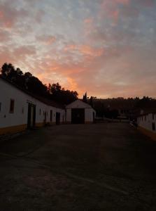 an empty parking lot with a sunset in the background at Horse Riding Country House in Vila Franca de Xira