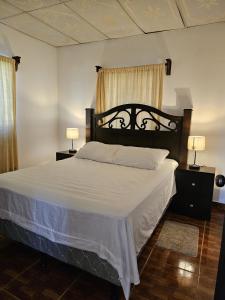 - une chambre avec un grand lit et des draps blancs dans l'établissement La casa de la Gaviota, à Siguatepeque