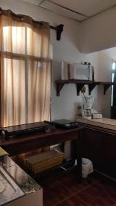 a kitchen with a table with a microwave and a window at La casa de la Gaviota in Siguatepeque