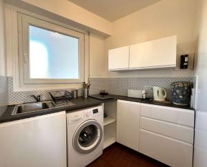 una cucina con lavatrice e lavandino di HYEDAV Studio climatisé pour 4 personnes à 50 m de la plage - Les Salins d'Hyères a Les Salins dʼHyères