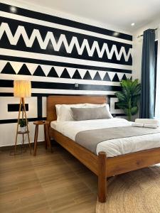 een slaapkamer met een bed met een zwart-witte muur bij Coalescence Hotel Rwanda in Kigali