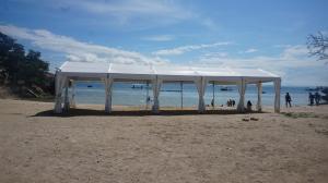 una tienda blanca en una playa cerca del agua en The Beach Park Hadsan en Lapu Lapu City