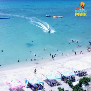 una playa con un montón de gente en el agua en The Beach Park Hadsan en Lapu Lapu City