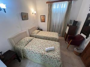 a hotel room with two beds and a chair at Nostalgia Boutique Hotel Girne in Kyrenia
