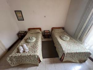 2 łóżka w małym pokoju z ręcznikami w obiekcie Nostalgia Boutique Hotel Girne w mieście Kirenia