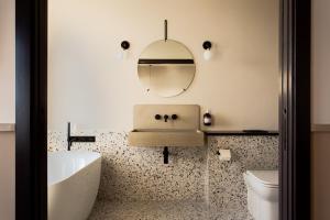 a bathroom with a sink and a toilet and a mirror at Port Hotel in Eastbourne