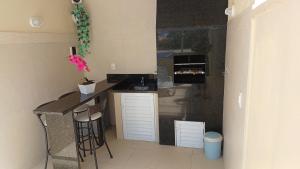 a small kitchen with a counter and stools in it at Uma agradável morada para descansar com a família ! in Governador Celso Ramos