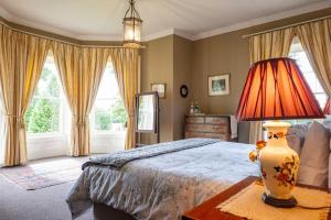 a bedroom with a bed and a lamp on a table at Kilfane Glebe House in Thomastown