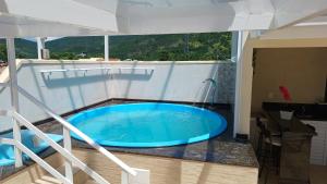 een groot blauw bad midden op een balkon bij Uma agradável morada na praia para descansar ! in Governador Celso Ramos