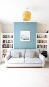 a living room with a white couch and a blue wall at Charming Character House in Beautiful Neighborhood in Belfast