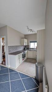 uma grande cozinha com armários brancos e pisos em azulejo azul em Charming Character House in Beautiful Neighborhood em Belfast