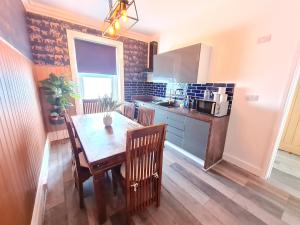 a kitchen with a wooden table with chairs and a dining room at Lemur Lodge - Boutique Apartments - Short Stroll to The Beach in Bournemouth