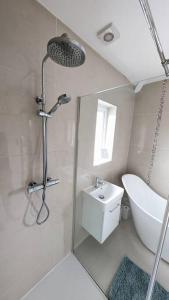 baño blanco con ducha y lavamanos en Charming Character House in Beautiful Neighborhood, en Belfast
