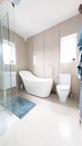 baño blanco con bañera y aseo en Charming Character House in Beautiful Neighborhood en Belfast
