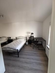 a bedroom with two beds and a desk and a chair at Haus Jürgens in Recklinghausen