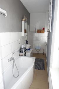 a white bathroom with a tub and a sink at Ferienwohnung im Logierhaus Villa Ihler in Luisenthal