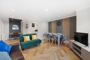 sala de estar con sofá verde y comedor en Spacious Stunning Flat near Heathrow and Central London, en Hounslow