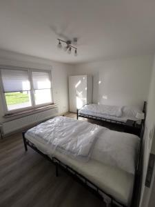 2 camas en una habitación con 2 ventanas en Haus Jürgens en Recklinghausen