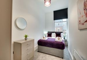 a bedroom with a bed and a mirror at Lord Grey Apartments by Week2Week in Newcastle upon Tyne