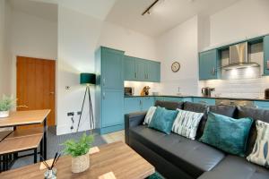 a living room with a couch and a kitchen at Lord Grey Apartments by Week2Week in Newcastle upon Tyne