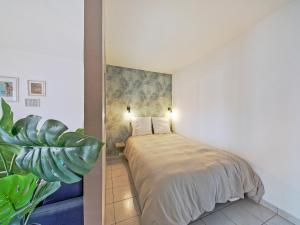 ein Schlafzimmer mit einem Bett und einer Pflanze in der Unterkunft Prague - 10min de Disneyland Paris Parking privé in Montévrain