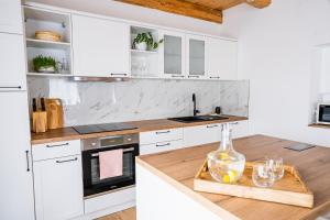 a kitchen with white cabinets and a wooden counter top at Pri stari mami in Tomaž pri Ormožu