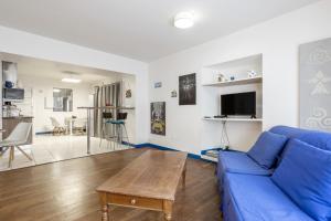 ein Wohnzimmer mit einem blauen Sofa und einem Tisch in der Unterkunft Appartement 4 pers 400m de la plage in Le Guilvinec