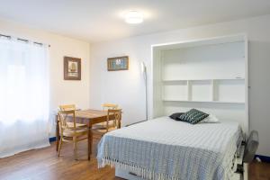 ein Schlafzimmer mit einem Bett und einem Tisch sowie ein Esszimmer in der Unterkunft Appartement 4 pers 400m de la plage in Le Guilvinec