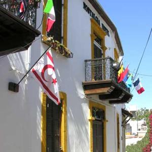 un edificio con banderas, balcón y bandera en Nostalgia Boutique Hotel Girne en Kyrenia