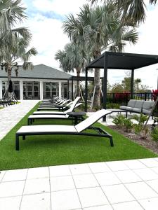 eine Reihe von Bänken in einem Hof mit Palmen in der Unterkunft Boho Chic Luxury Retreat 5 Min to Parks & Food in Orlando