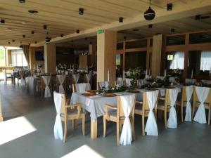 a banquet hall with white tables and chairs with flowers at Resort Levočská Dolina in Levoča