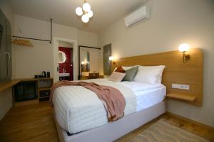 a bedroom with a large bed with a wooden headboard at Living Yard Acropolis in Athens