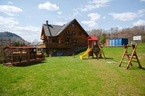 a house with a playground in a field at Resort Levočská Dolina in Levoča