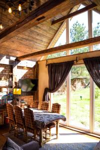une salle à manger avec une table, des chaises et des fenêtres dans l'établissement Ptasia Osada, à Gardna Wielka