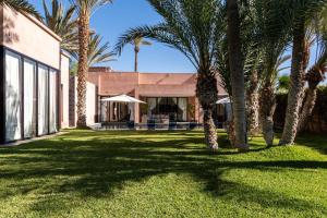 ein Haus mit Palmen im Hof in der Unterkunft Luxury 5bed villa with heated pool in Marrakesch