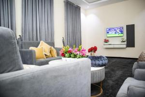 a living room with couches and a tv at Pula Pula Luxury Hotel and Suites in Karewa