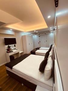 Una habitación de hotel con dos camas y un escritorio. en Hodegon Suite Hotel, en Estambul