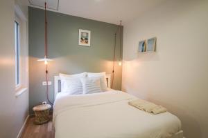 ein Schlafzimmer mit einem großen Bett mit weißen Kissen in der Unterkunft Lille Centre - Nice, cozy and functional ap. in Lille