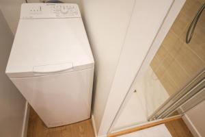 a white washer and dryer in a bathroom at Lille Centre - Nice, cozy and functional ap. in Lille
