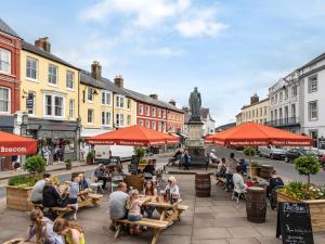 a group of people sitting at tables on a city street at 1 Bed in Brecon 91150 in Brecon