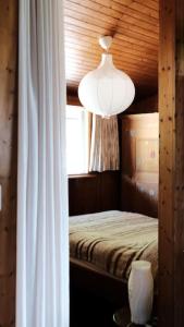 a bedroom with a bed with a light and a window at Drop In mountain chalet 