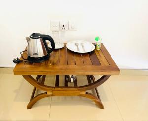 een houten tafel met een waterkoker en een bord erop bij Riparian Ahangama in Ahangama