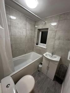 a bathroom with a toilet and a tub and a sink at Anfield end terraced home in Liverpool