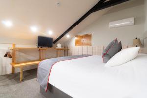 a bedroom with a large white bed and a tv at Collection O Coraz&oacute;n Del Caf&eacute; Hotel Boutique in Comit&aacute;n de Dom&iacute;nguez