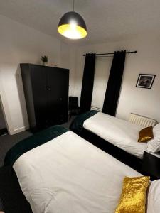 um quarto com 2 camas e um armário preto em Anfield end terraced home em Liverpool