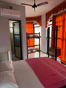 a bedroom with a bed with orange curtains at Hotel Art Final in Marataizes