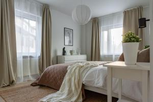 a bedroom with a bed with a table and windows at Sodermalm Hideaway Haven in Stockholm