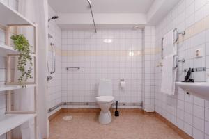 a white bathroom with a toilet and a sink at Sodermalm Hideaway Haven in Stockholm